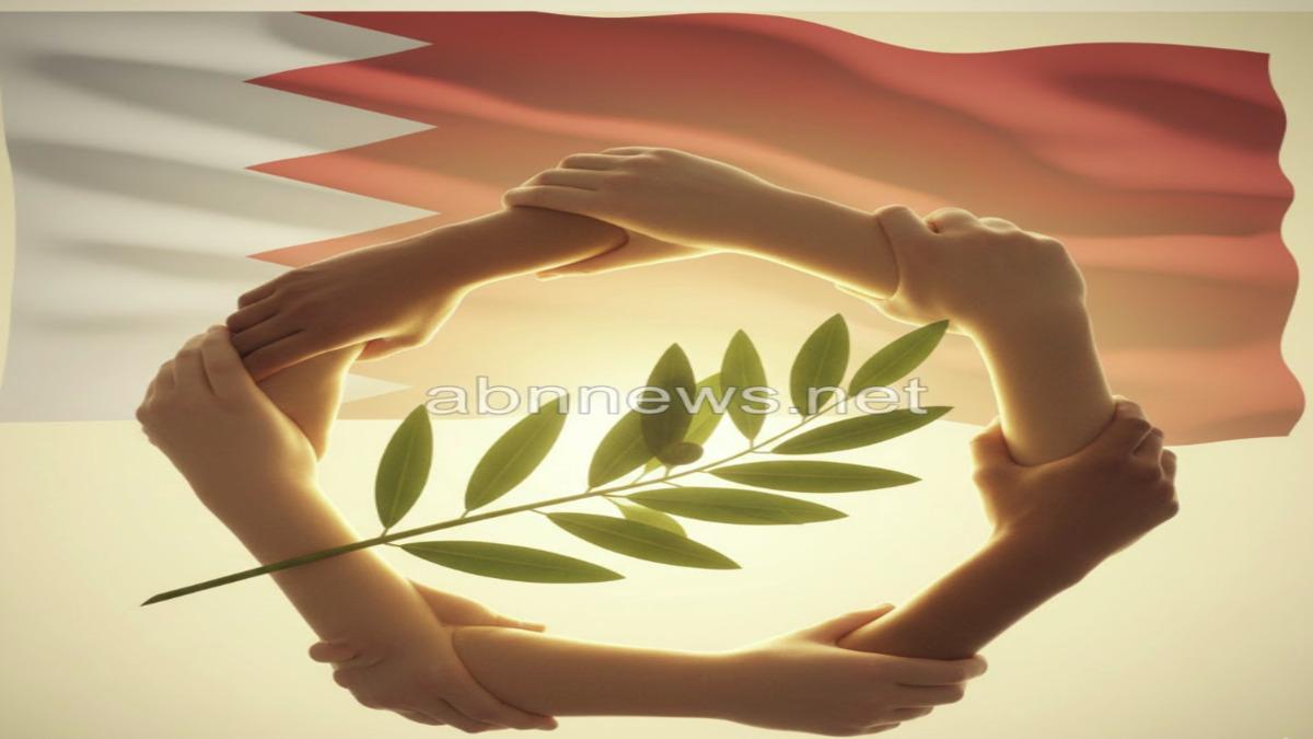 شعار رمزي يجمع أيادي مترابطة مع غصن زيتون أمام علم البحرين، يمثل قيم الجمعية البهائية الاجتماعية في التعايش السلمي، موقع abnnews.net.