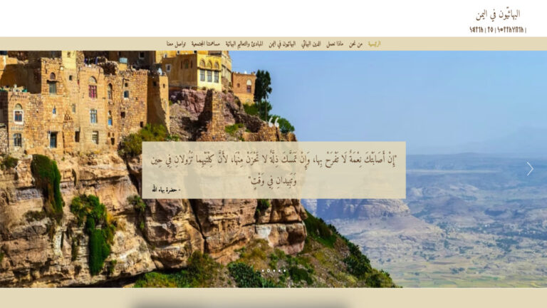 لقطة شاشة للصفحة الرئيسية لموقع البهائيين في اليمن تظهر بيوتاً يمنية أثرية على قمة جبل مع اقتباس ديني.