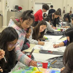 مجموعة من الشباب يشاركون في نشاط فني مجتمعي ضمن مبادرات الشباب البهائي والخدمة.