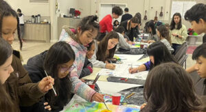 مجموعة من الشباب يشاركون في نشاط فني مجتمعي ضمن مبادرات الشباب البهائي والخدمة.